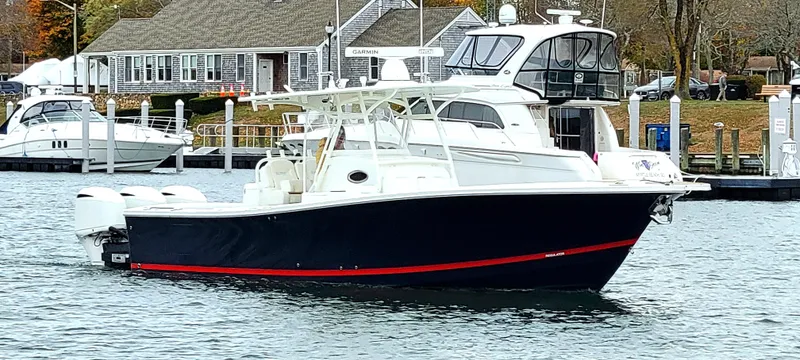 Slide: The Image of 2018 Regulator 34SS boat docked in a marina with waterfront buildings. - 3