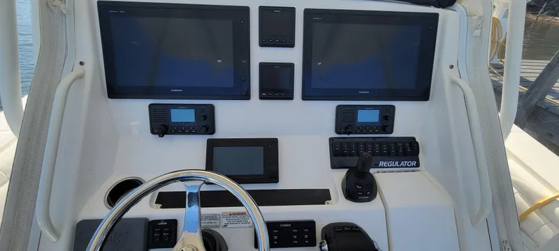 Slide: The Image of 2018 Regulator 34SS boat dashboard with multiple screens and controls. - 9