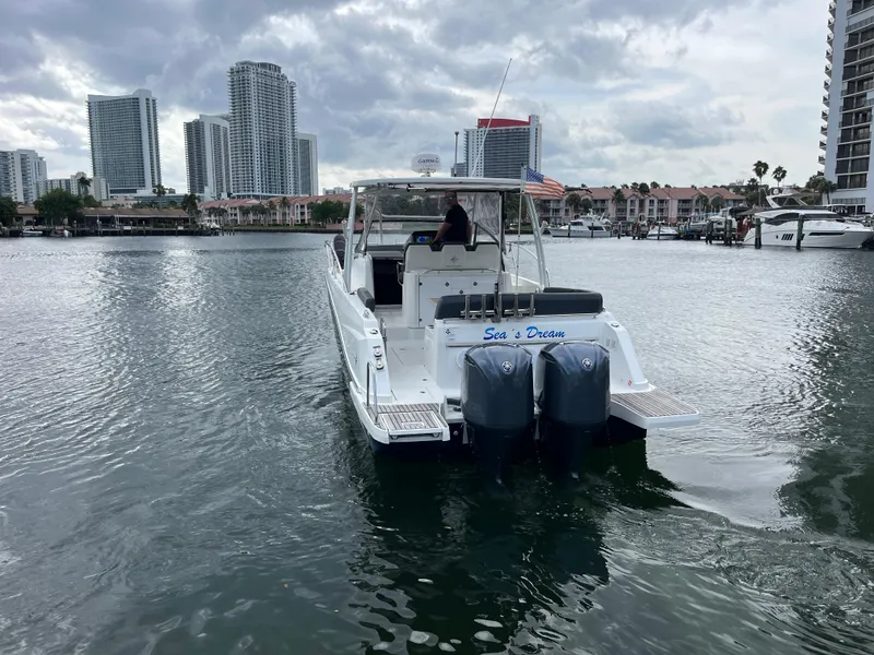 Slide: The Image of 2019 Jeanneau Leader 10.5 boat cruising in urban waterfront setting. - 14