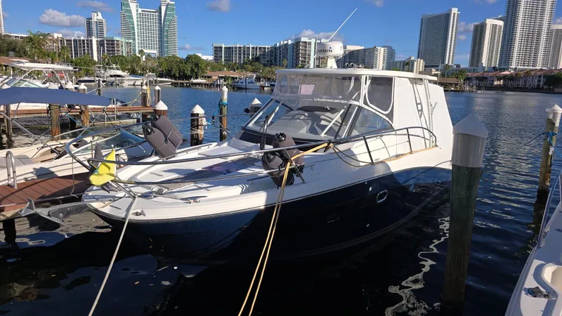 Slide: The Image of 2019 Jeanneau Leader 10.5 boat docked in a marina with city skyline. - 17
