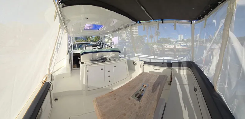 Slide: The Image of 2019 Jeanneau Leader 10.5 boat interior with seating and table, docked in a marina. - 20