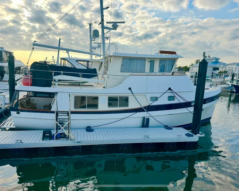 Slide: The Image of 2001 Kadey-Krogen 48 Whaleback yacht docked at marina under cloudy sky. - 1