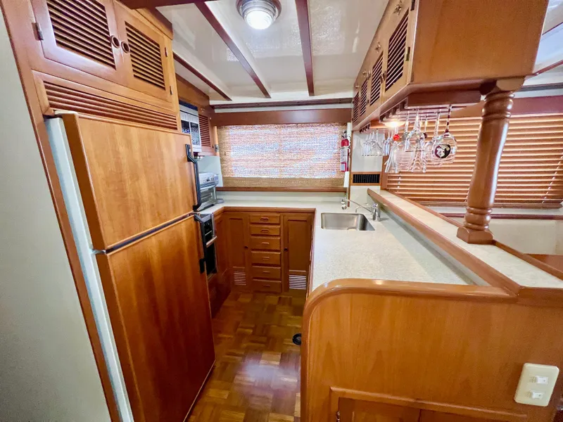 Slide: The Image of 2001 Kadey-Krogen 48 Whaleback yacht kitchen with wood cabinetry and modern appliances. - 12