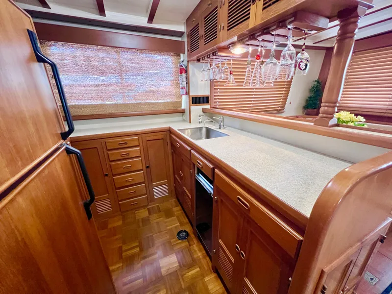 Slide: The Image of Luxurious 2001 Kadey-Krogen 48 Whaleback yacht kitchen with wood cabinetry and modern amenities. - 14