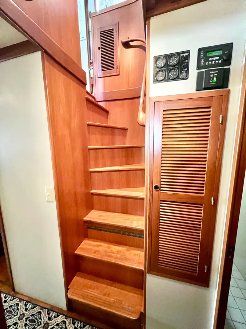 Slide: The Image of Wooden staircase inside 2001 Kadey-Krogen 48 Whaleback yacht with control panels. - 22