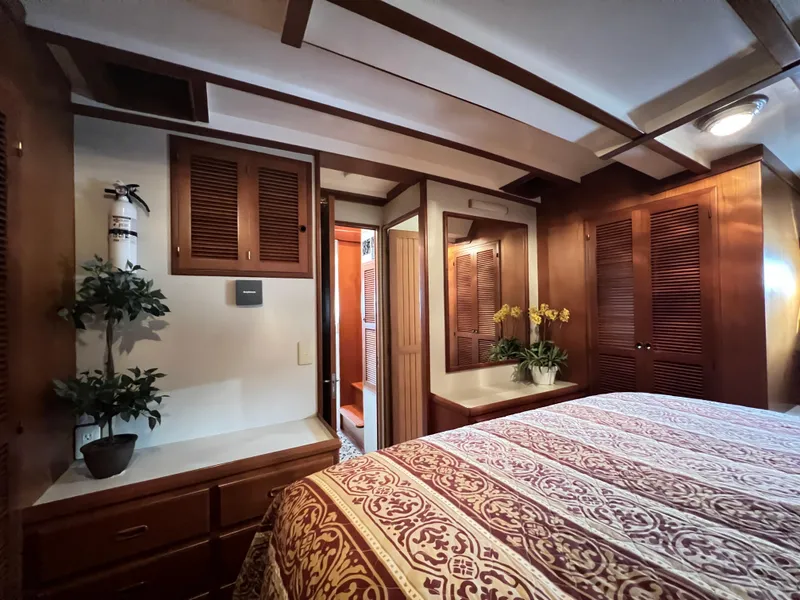 Slide: The Image of Luxurious 2001 Kadey-Krogen 48 Whaleback yacht bedroom with elegant wood finishes and floral decor. - 27