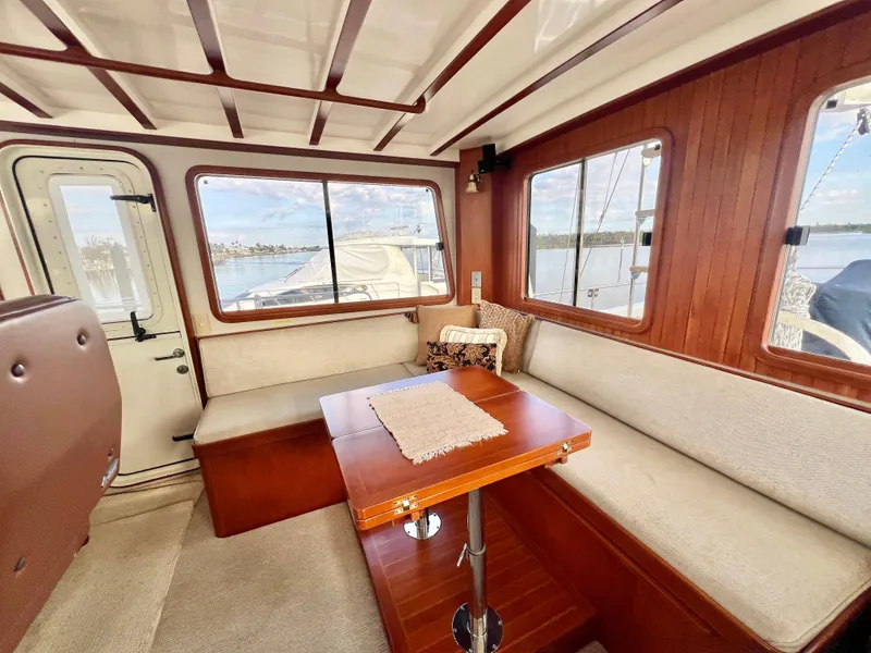 Slide: The Image of Interior of 2001 Kadey-Krogen 48 Whaleback yacht with cozy seating and wooden table. - 33