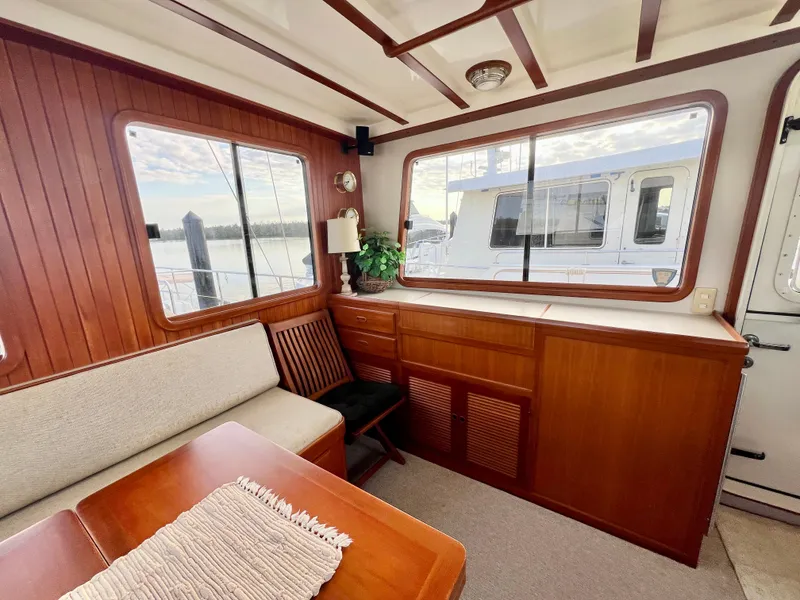 Slide: The Image of Interior of 2001 Kadey-Krogen 48 Whaleback yacht with wooden furnishings and large windows. - 34