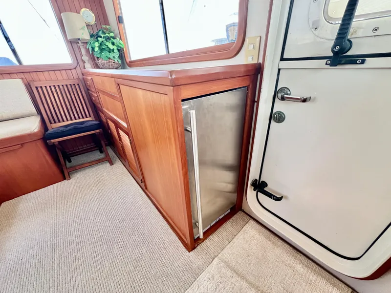 Slide: The Image of Interior of 2001 Kadey-Krogen 48 Whaleback yacht with wooden cabinetry and stainless steel fridge. - 36