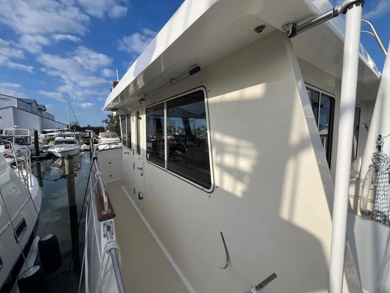 Slide: The Image of 2001 Kadey-Krogen 48 Whaleback yacht docked at marina under blue sky. - 43