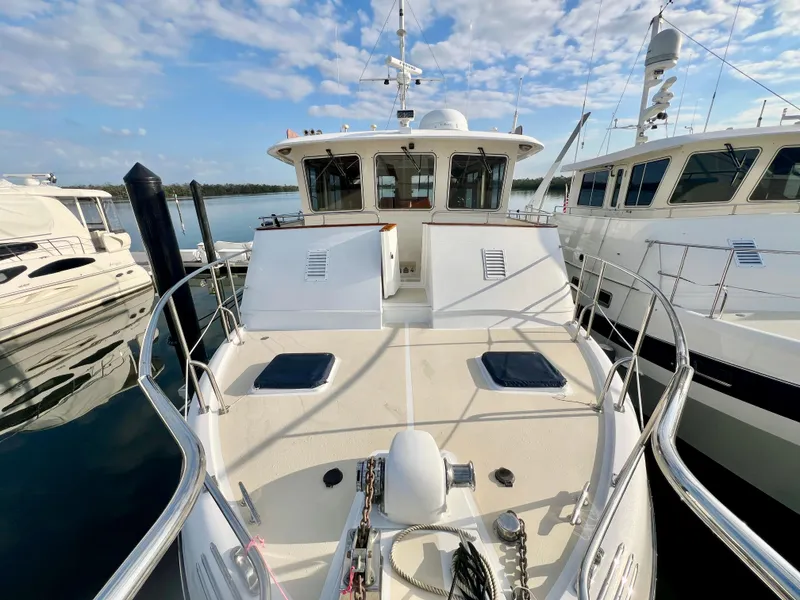 Slide: The Image of Kadey-Krogen 48 Whaleback 2001 yacht docked, showcasing spacious deck and sleek design. - 46