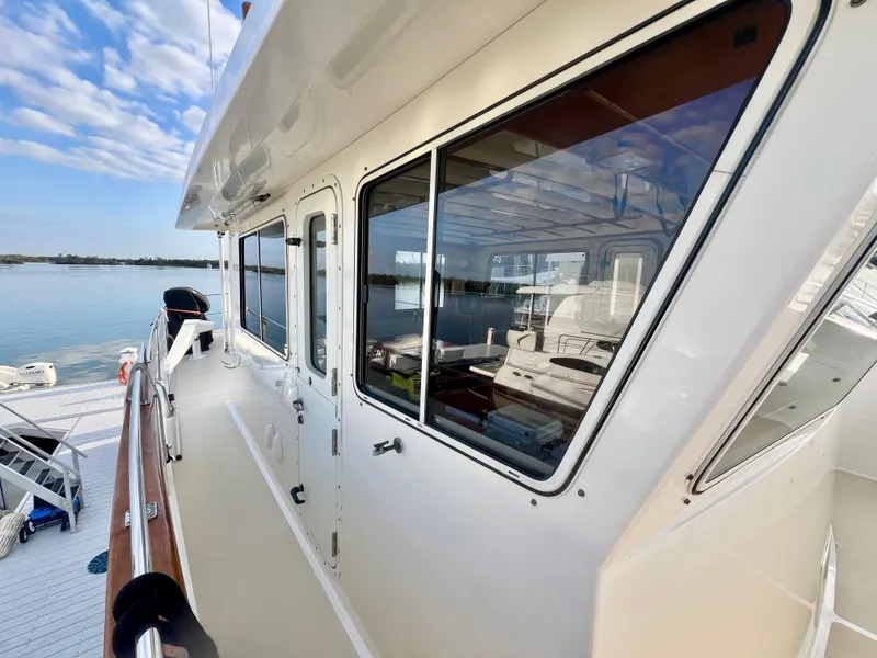 Slide: The Image of 2001 Kadey-Krogen 48 Whaleback yacht exterior with windows, docked by calm water. - 48