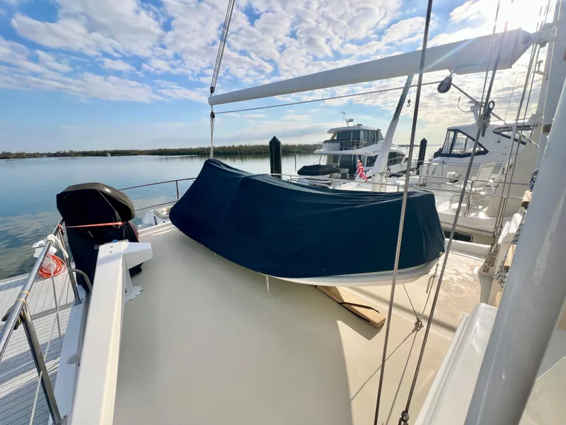 Slide: The Image of 2001 Kadey-Krogen 48 Whaleback yacht deck with covered equipment, docked by calm waters. - 50