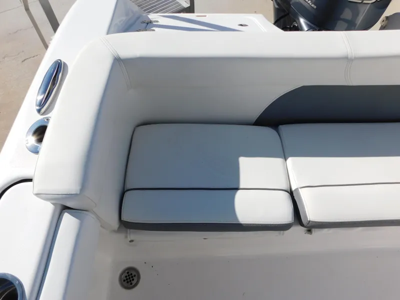 Slide: The Image of 2017 Tidewater 220 LXF boat seating area with white cushions and cup holders. - 11