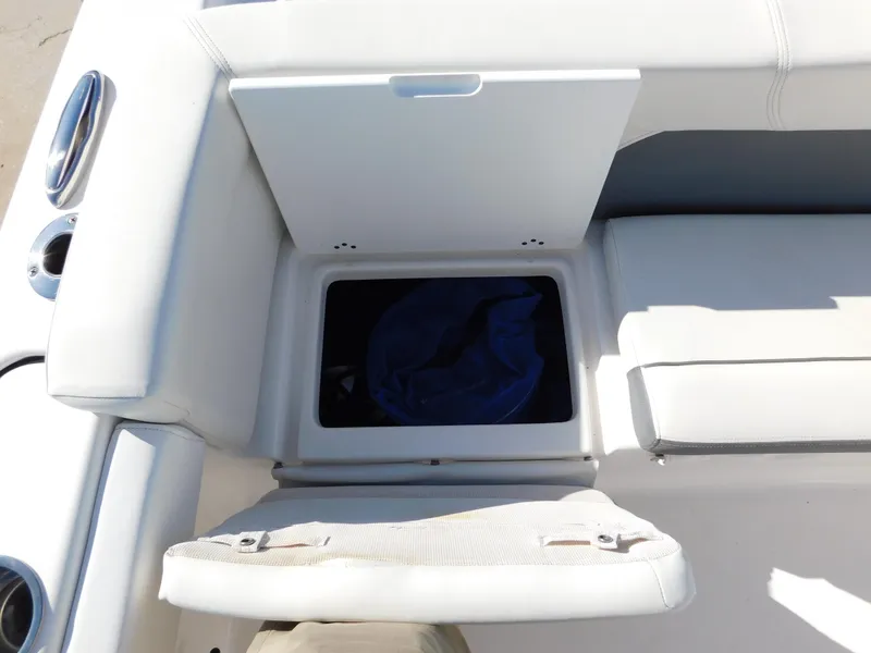 Slide: The Image of 2017 Tidewater 220 LXF boat storage compartment with white cushioned seating. - 12