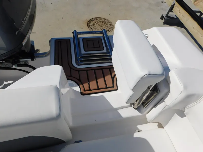 Slide: The Image of 2017 Tidewater 220 LXF boat interior with white seating and deck mats. - 17
