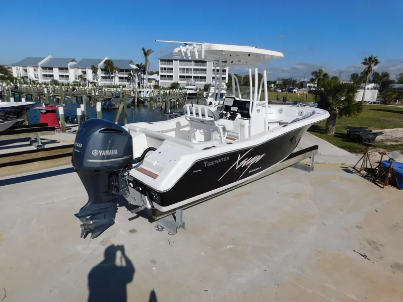 Slide: The Image of 2017 Tidewater 220 LXF boat with Yamaha engine, docked near waterfront buildings. - 2