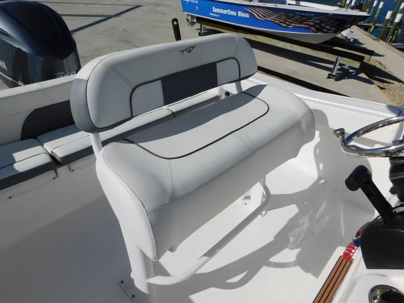 Slide: The Image of 2017 Tidewater 220 LXF boat seat with steering wheel, docked outdoors. - 24