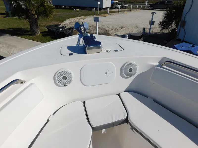Slide: The Image of 2017 Tidewater 220 LXF boat bow with seating and speakers, docked outdoors. - 27