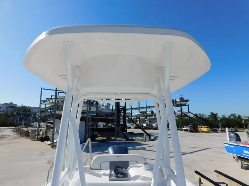 Slide: The Image of 2017 Tidewater 220 LXF boat with T-top, docked under clear blue sky. - 34