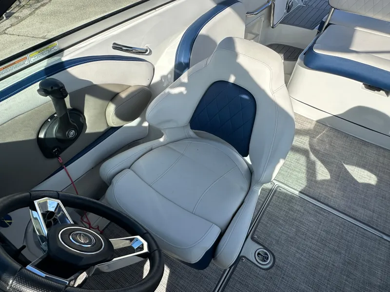 Slide: The Image of Interior of 2022 Crownline 260 XSS boat with steering wheel and seating. - 14