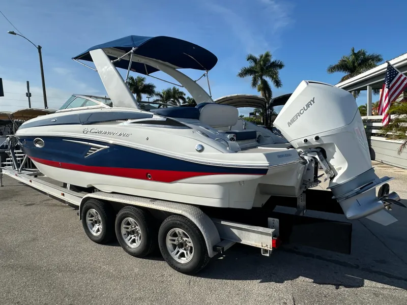 Slide: The Image of 2022 Crownline 260 XSS boat on trailer with Mercury outboard, palm trees in background. - 8