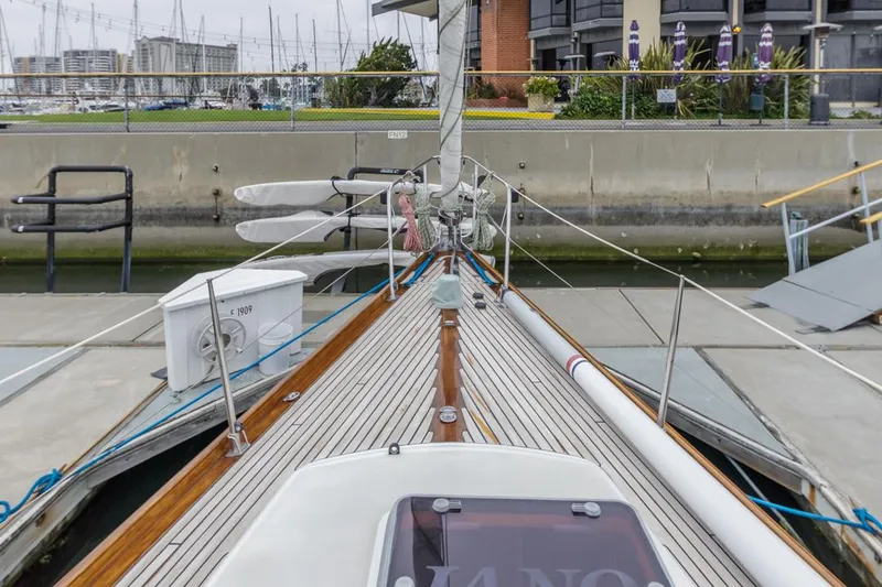 Slide: The Image of Farr 55 sailboat from 1994 docked at a marina, showcasing its deck and rigging. - 29