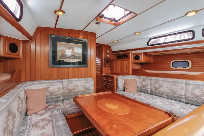 Slide: The Image of Luxurious 1994 Farr 55 yacht interior with wood paneling and cozy seating area. - 30