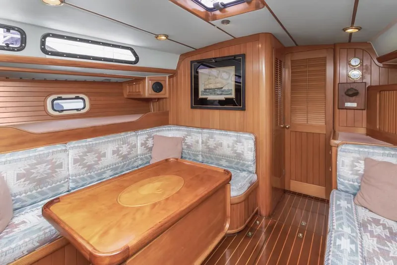 Slide: The Image of Interior of 1994 Farr 55 yacht with wooden furnishings and cozy seating area. - 33