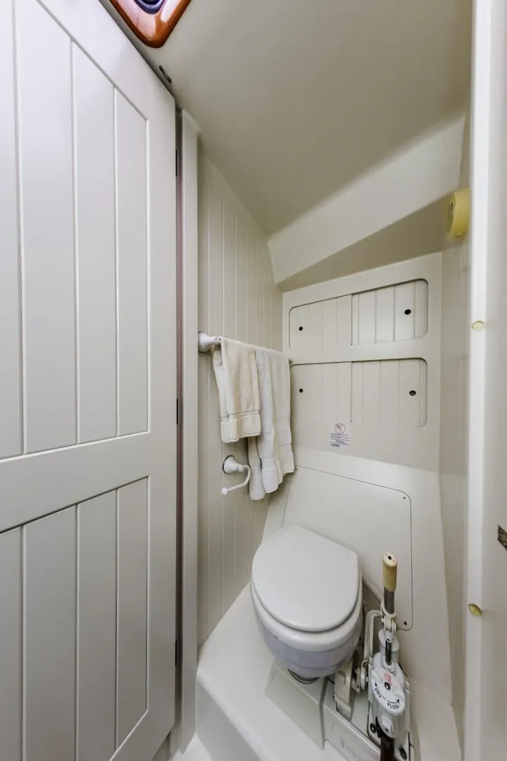Slide: The Image of Compact bathroom in 1994 Farr 55 yacht with white fixtures and storage. - 41