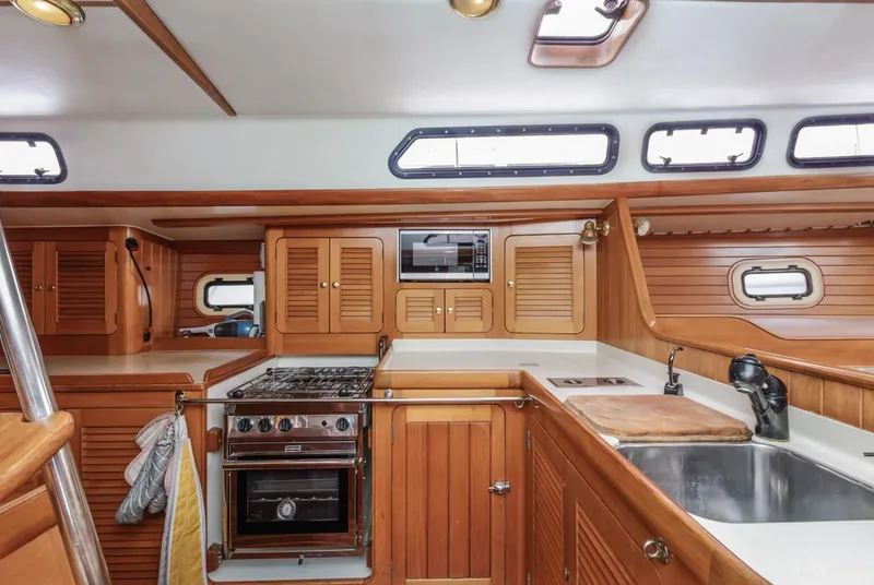 Slide: The Image of Interior of 1994 Farr 55 yacht kitchen with wooden cabinetry and modern appliances. - 44