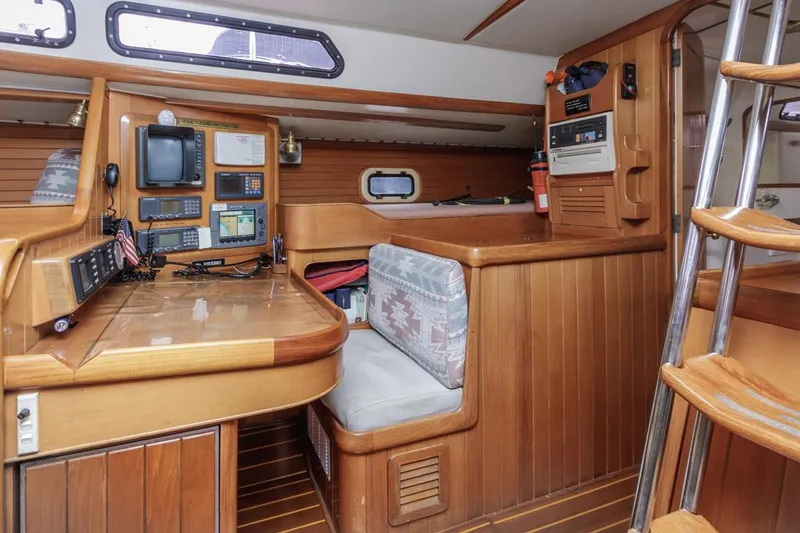 Slide: The Image of Interior of 1994 Farr 55 yacht with navigation station and wooden furnishings. - 48