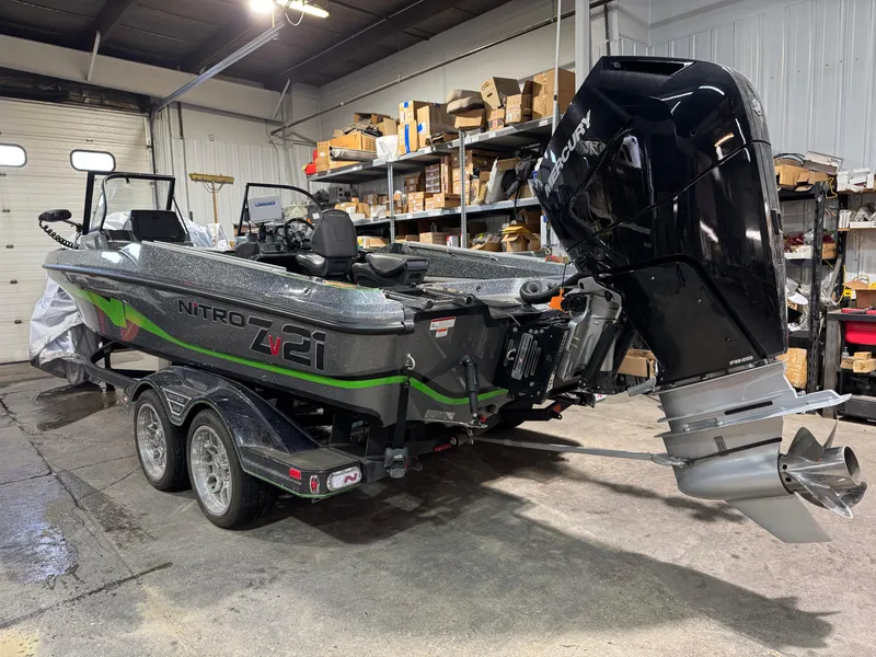 Slide: The Image of 2024 Nitro ZV21 Pro boat with powerful outboard motor in a garage setting. - 5