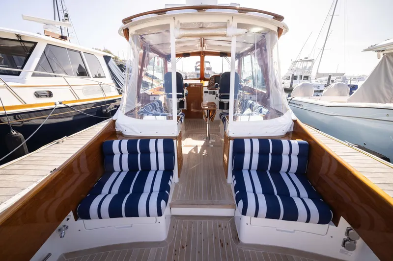 Slide: The Image of 2016 Hinckley 37 Picnic Boat with striped seating, docked at a marina. - 13