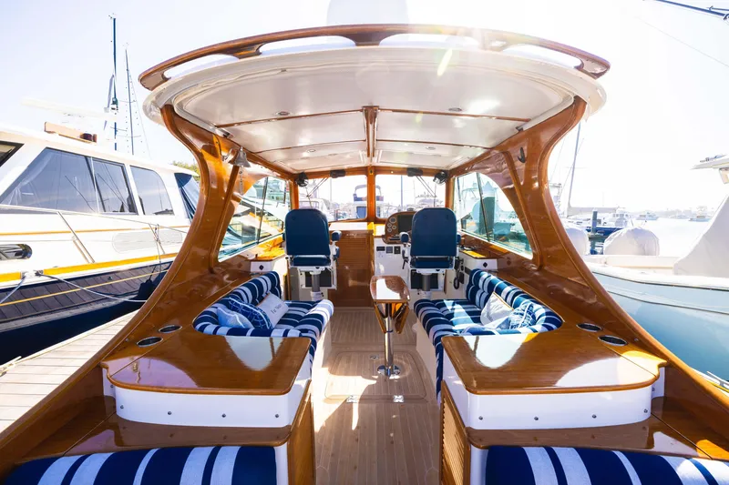 Slide: The Image of Luxurious 2016 Hinckley 37 Picnic Boat interior with striped seating and polished wood finish. - 14