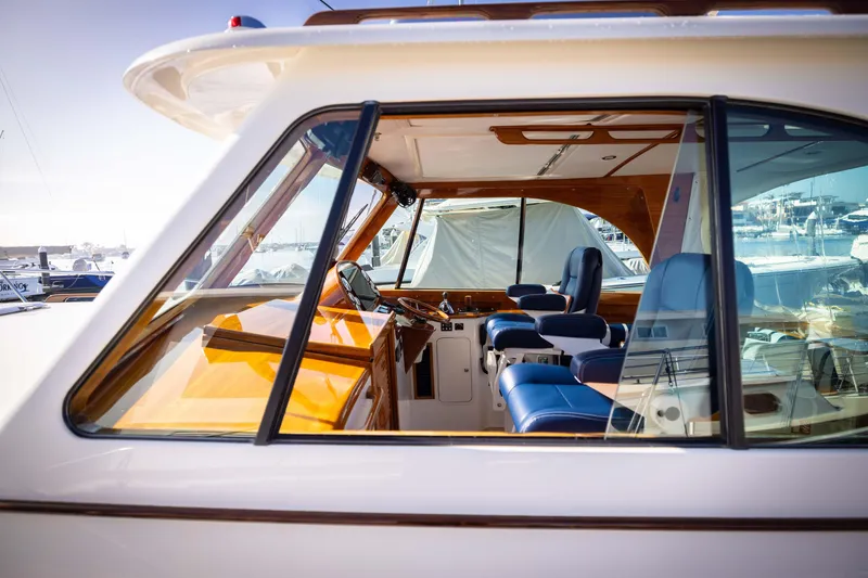 Slide: The Image of 2016 Hinckley 37 Picnic Boat interior with blue seating and wooden accents. - 15