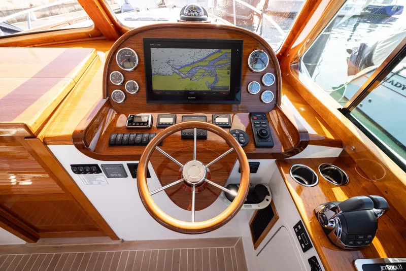 Slide: The Image of Hinckley 37 Picnic Boat 2016 helm with navigation display and wooden steering wheel. - 19