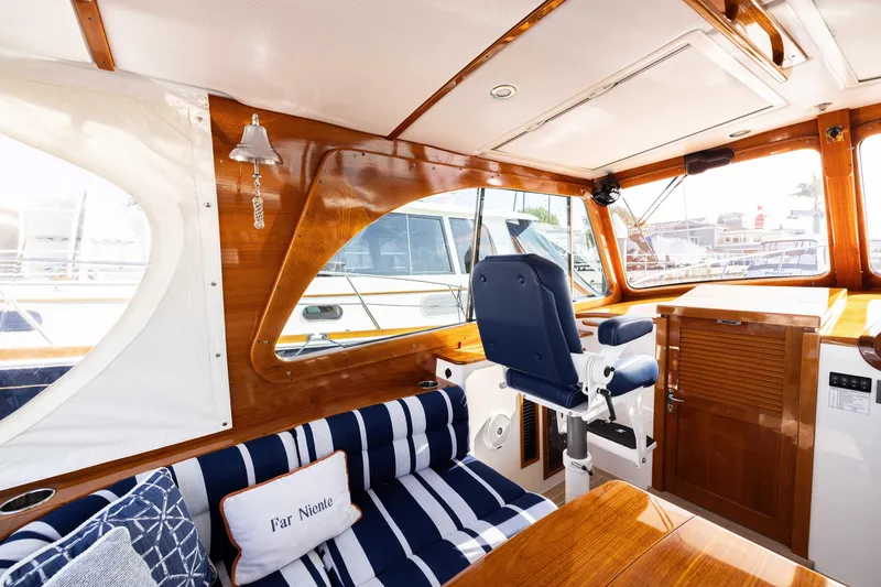 Slide: The Image of Interior of 2016 Hinckley 37 Picnic Boat with elegant wood finish and striped seating. - 20