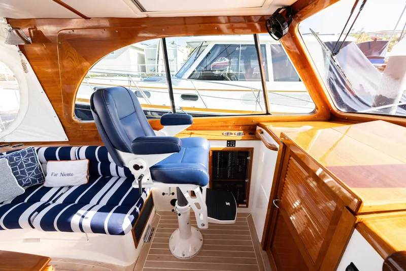 Slide: The Image of Interior of 2016 Hinckley 37 Picnic Boat with blue seating and wooden finishes. - 21