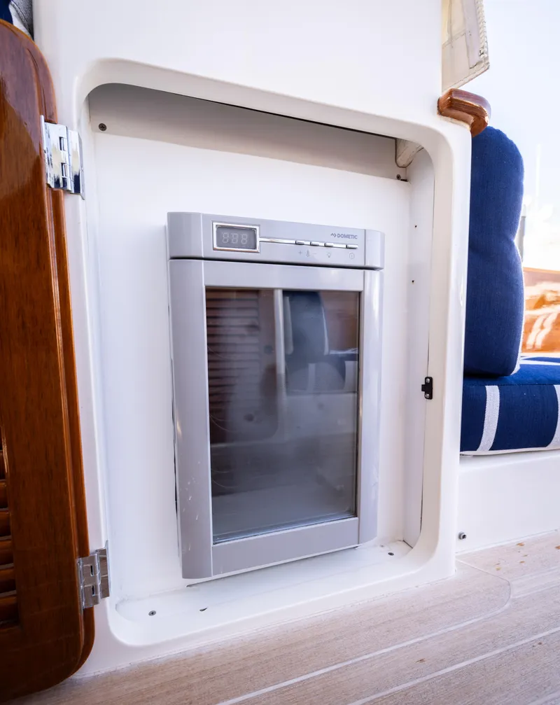 Slide: The Image of Hinckley 37 Picnic Boat 2016 interior fridge detail with blue seating. - 23