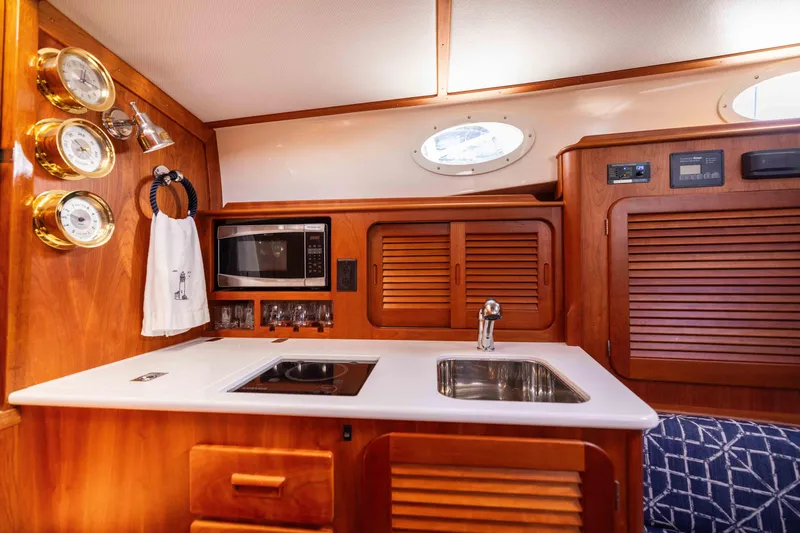 Slide: The Image of Hinckley 37 Picnic Boat 2016 interior kitchen with sink, stove, and microwave. - 27