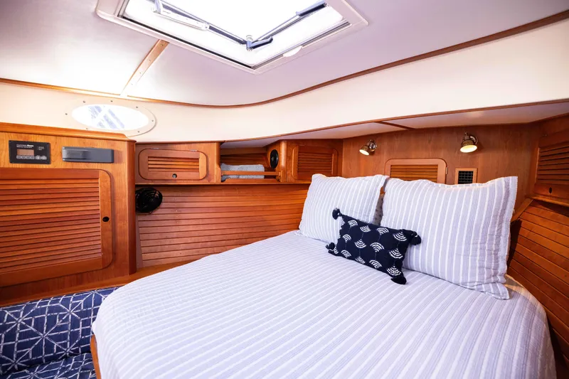 Slide: The Image of Hinckley 37 Picnic Boat 2016 cabin interior with cozy bed and wooden paneling. - 31