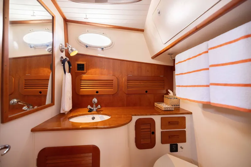 Slide: The Image of Elegant 2016 Hinckley 37 Picnic Boat bathroom with wood accents and modern fixtures. - 32