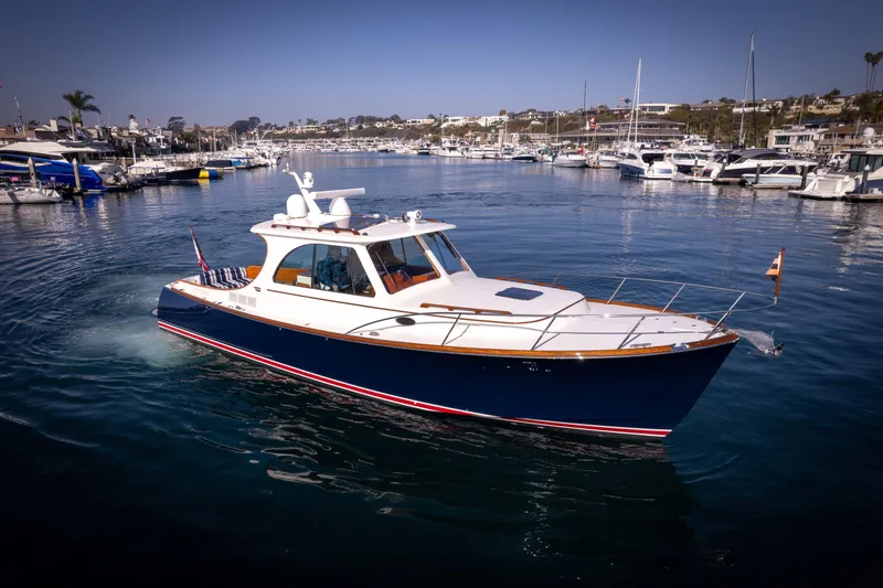 Slide: The Image of 2016 Hinckley 37 Picnic Boat cruising in a marina, surrounded by other boats. - 36