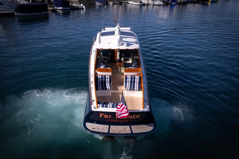 Slide: The Image of Hinckley 37 Picnic Boat 2016 cruising in a marina, rear view with American flag. - 38