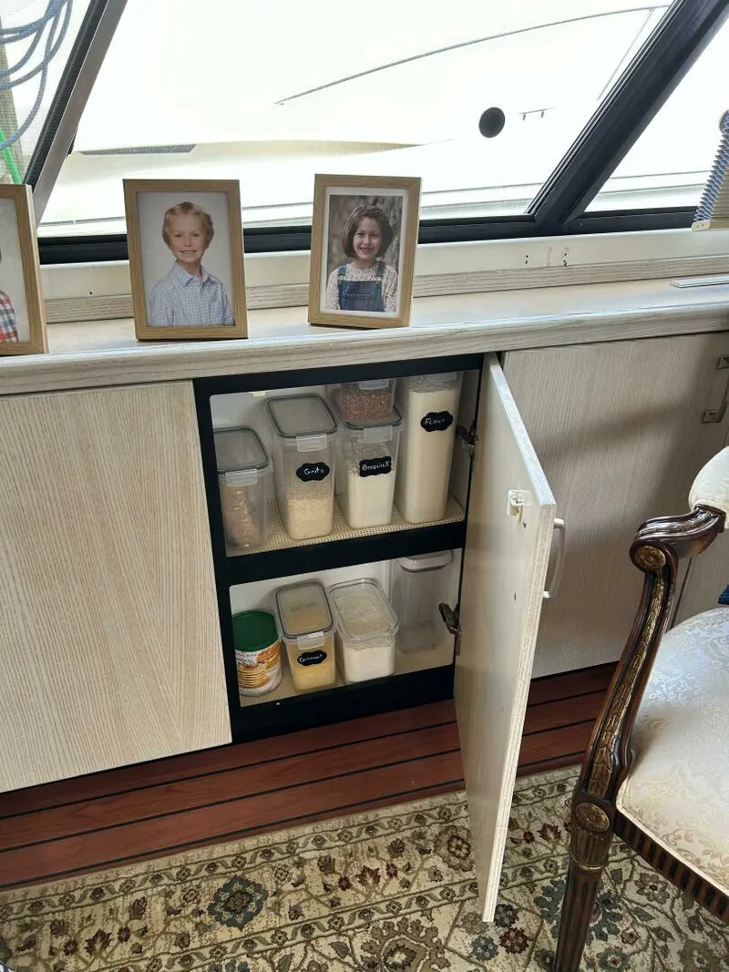 Slide: The Image of Interior of 1996 Bayliner 4788 yacht with storage cabinet and framed photos. - 23