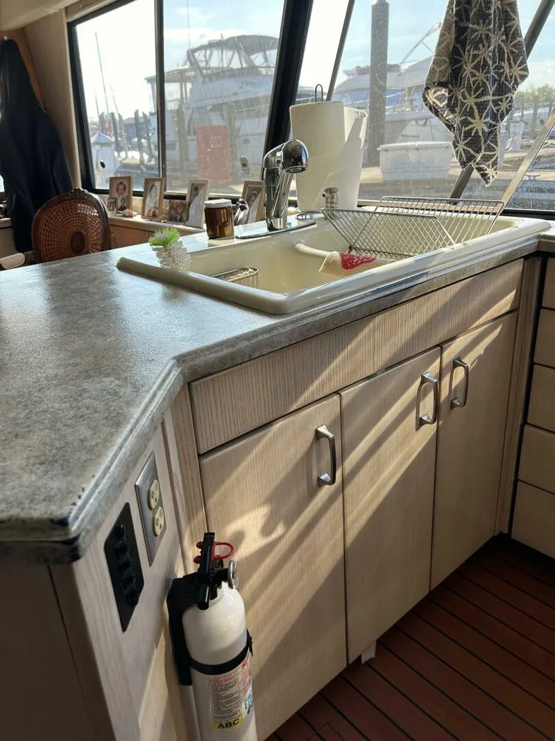Slide: The Image of 1996 Bayliner 4788 Pilot House Motoryacht kitchen with sink, countertop, and cabinets. - 27