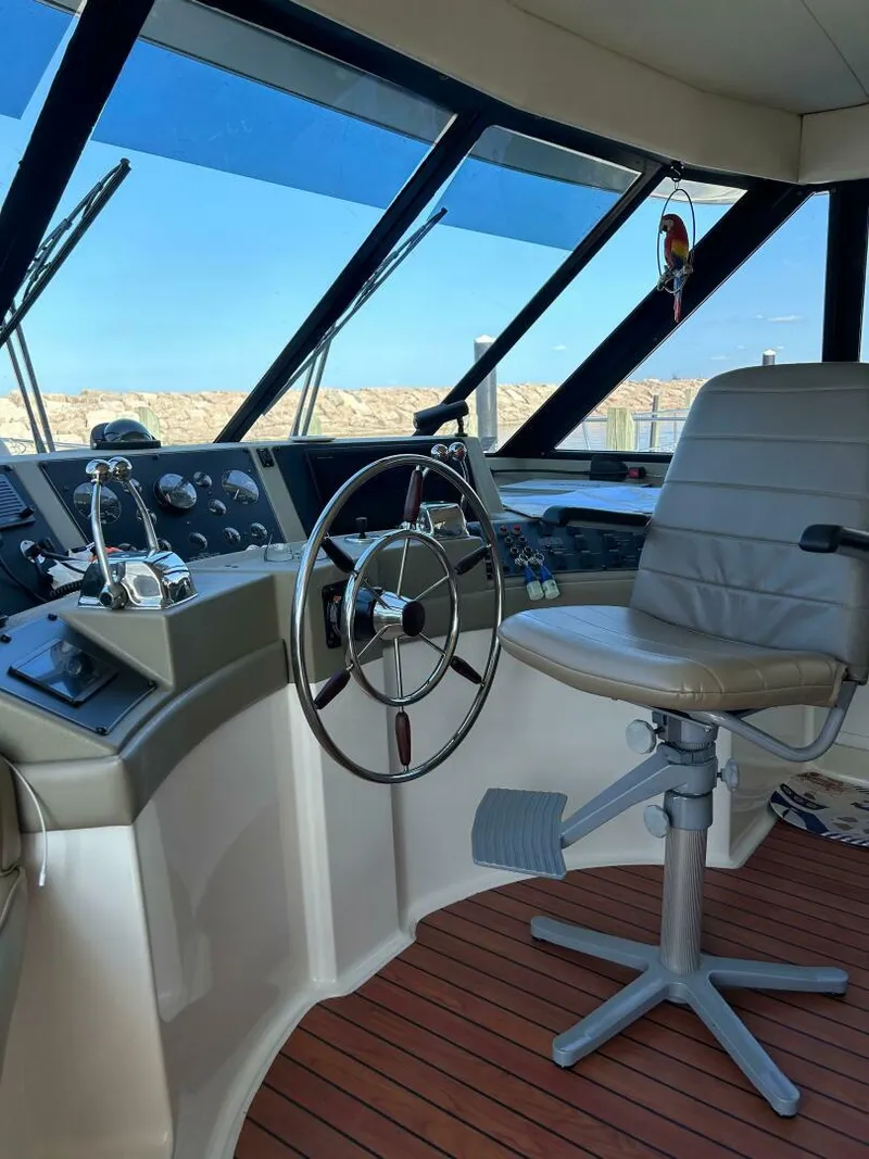Slide: The Image of 1996 Bayliner 4788 Pilot House Motoryacht helm with steering wheel and captain's chair. - 4