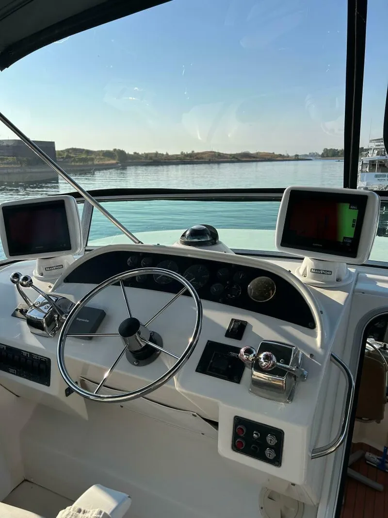 Slide: The Image of 1996 Bayliner 4788 Pilot House Motoryacht helm with dual monitors and steering wheel. - 5