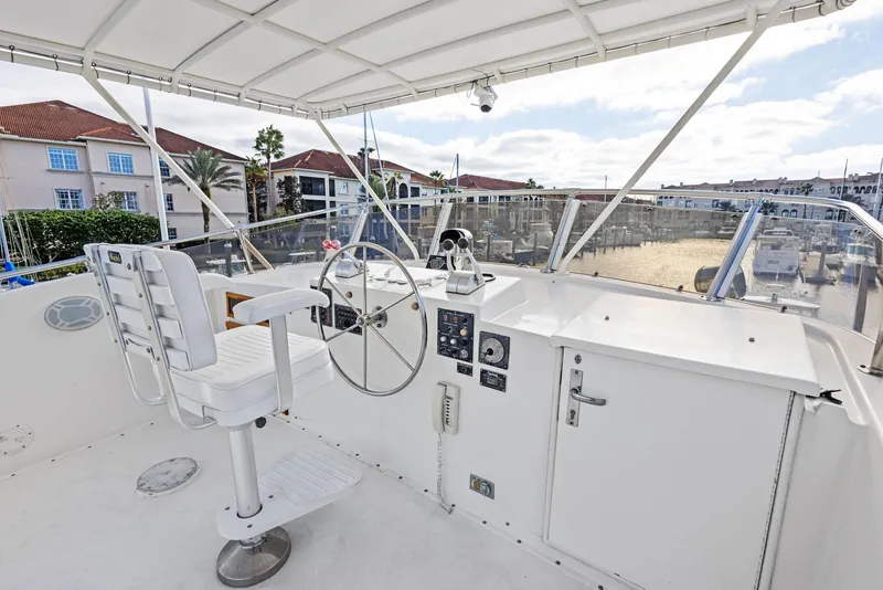 Slide: The Image of 1987 Hatteras 68 Cockpit Motor Yacht helm with steering wheel and controls. - 12